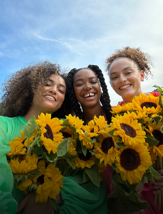 Một bức ảnh selfie sắc nét và sống động chụp cảnh ba người đang cầm hoa.